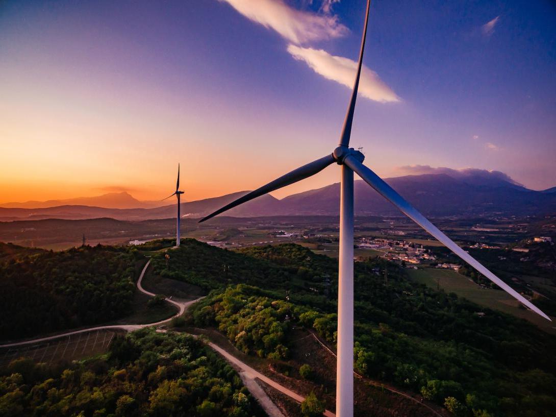 Wind turbines windmill energy farm at sunset